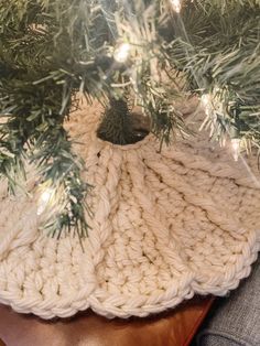 a white knitted hat hanging from a tree