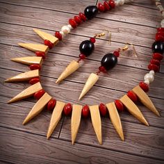 a necklace and earring set made out of wood with red, black and white beads