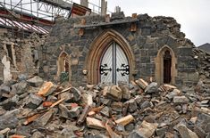 a large pile of rubble in front of a building with a white door and window