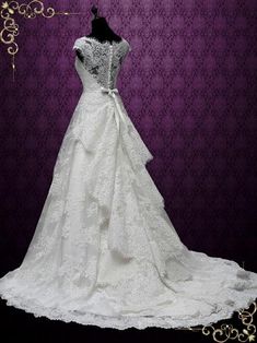 a wedding dress on display in front of a purple background