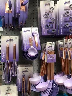 purple and gold kitchen utensils on display in a store with price tags for each item