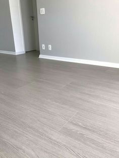 an empty room with white walls and wood flooring is seen in this image from the doorway