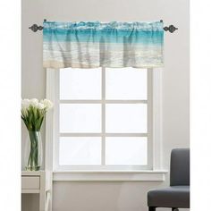 a window with flowers in front of it and an ocean scene on the curtain valance