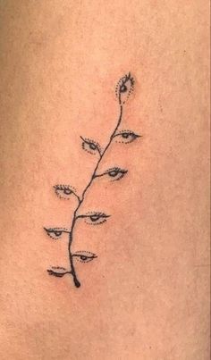 a small tattoo on the back of a woman's lower thigh, with flowers growing out of it