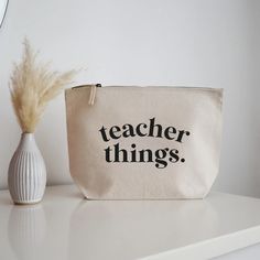 This pouch makes a lovely practical gift idea for a teacher that holds lots of teacher essentials like pens, pencils, hand gel, tissues, first aid kit and lots of other teacher things.  DETAILS - Available with black or sand coloured text.  - This bag is made from 100% brushed cotton canvas with a sturdy vintage style metal zip closure. - Dimensions: 13cm x 19.5cm x 6 cm All orders are hand-wrapped, complete with shredded paper and tied up in a bow.  If you wish to send a gift message along with Teacher Bag Designs, Teacher Bag Essentials, Teacher Canvas Bag, Teacher Gift Bags, Stationary Bag, Teacher Bag, Teacher Bags