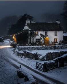 a white house sitting on the side of a snow covered road