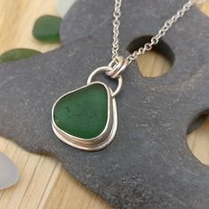 I found this teardrop shaped piece of sea glass on Seaham Beach, while on a recent holiday in County Durham.  It is a beautiful deep, rich shade of emerald green that almost seems to glow in sunlight.  The glass is set in a Fine Silver bezel and sits on 0.8 mm Sterling Silver sheet.  The two bail loops and the top loop are made from 1mm round Sterling Silver wire.  The pendant is approximately 24 mm long including the bail loops and is 15.5 mm wide.  The sea glass measures approximately 15 mm x Green Teardrop Glass Jewelry, Seaglass Jewellery, Seaham Beach, Silver Smithing, Soldered Jewelry, 2023 Art, Silver Clay, Metalwork Jewelry, Glass Drop Earrings