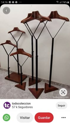 three metal and wood clothes racks in the shape of umbrellas