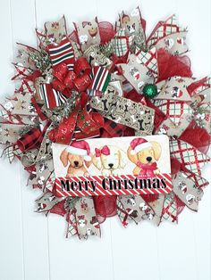 a christmas wreath with two teddy bears on it and a merry message in the center