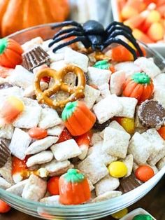 a bowl full of halloween treats with candy and pretzels on the side,