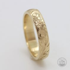 a gold wedding ring with flowers on it