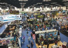 an overhead view of a convention hall with people walking around and booths in the center