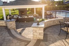 an outdoor patio with seating and fire pit in the back yard, next to a swimming pool