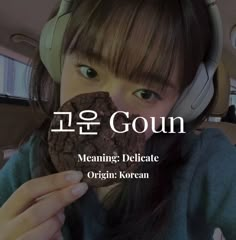 a girl wearing headphones eating a cookie with the words meaning delicate origin korean