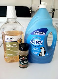 the contents of a dishwasher sitting on top of a counter next to a bottle of detergent