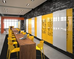 a long table with yellow chairs is in the middle of a room that has chalk writing on the walls