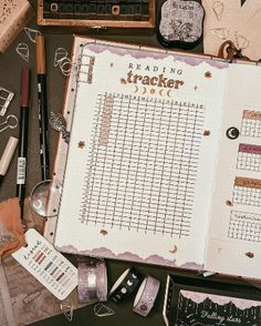 an open book sitting on top of a table filled with crafting supplies and other items