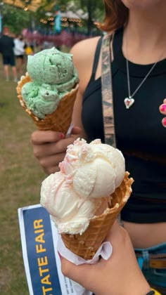 a woman holding two ice cream cones in her hands