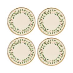 four plates with holly designs on them