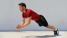 a man in red shirt and black shorts playing with a frisbee on cement