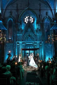 a bride and groom standing in front of an alter at a wedding ceremony with candles lit