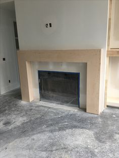 an empty room with a fireplace and shelves