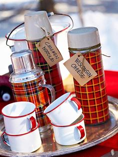 red and white coffee cups are on a silver tray with tags attached to the mugs