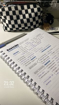 an open notebook sitting on top of a desk next to a pen and pencil holder