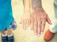 two people holding hands while standing next to each other on the ground with their fingers extended