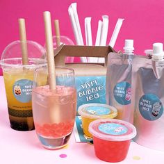 various drinks are lined up in front of a box with straws and paper cups