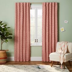 a living room with pink curtains and a white chair