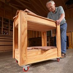 a man working on a wooden table with wheels