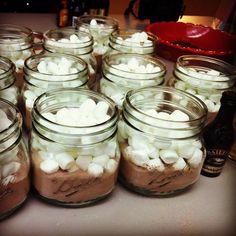 there are many mason jars with marshmallows in them