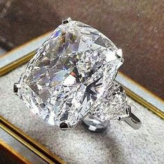 a large diamond ring sitting on top of a table