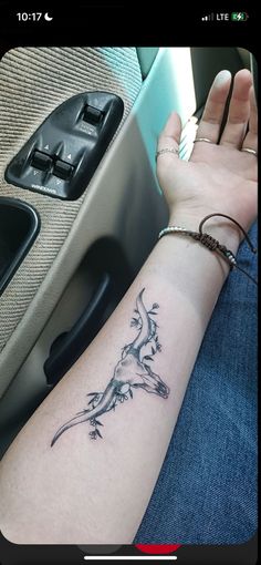 a person with a tattoo on their arm sitting in a car