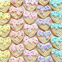 many heart shaped cookies with sprinkles on them are arranged in the shape of waffles