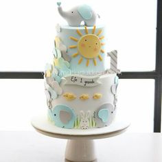 a three tiered cake decorated with elephants and giraffes