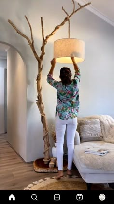 a woman standing next to a tree with a lamp on it