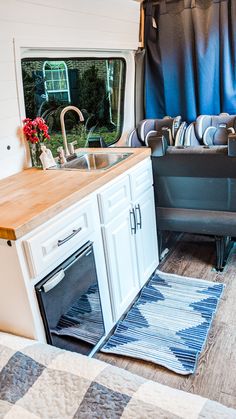 a kitchen area with sink, stove and cabinets in a camper van or truck