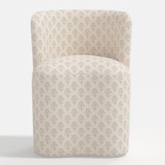 an upholstered chair with a white and beige floral pattern on the backrest