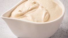 a white bowl filled with cream sitting on top of a counter