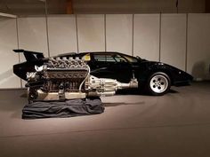 a black sports car with an engine on display