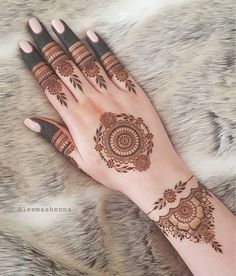 a woman's hand with henna tattoos on it