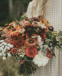 a woman holding a bouquet of flowers in her hands