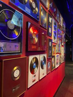 there are many records on the wall in this room with red and blue lights behind them