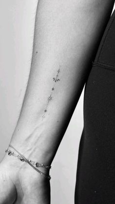 a woman's arm with a small star tattoo on the left side of her wrist