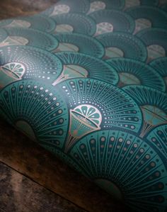 an upholstered seat cushion on a wooden floor with blue and green designs in the background