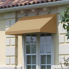 a yellow awning on the side of a building next to a potted plant