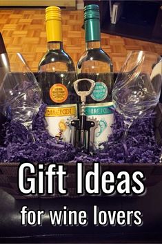 wine bottles and glasses in a gift box with purple shredded paper on the floor next to it