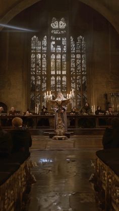 an empty church with pews, candles and stained glass windows in the back ground